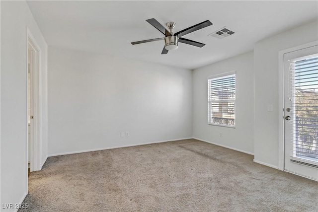 spare room with ceiling fan and light colored carpet