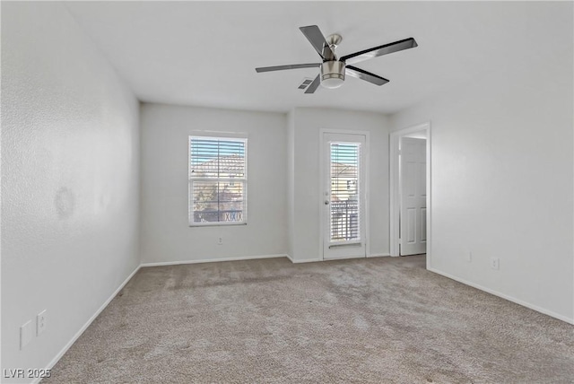 spare room with ceiling fan and light carpet