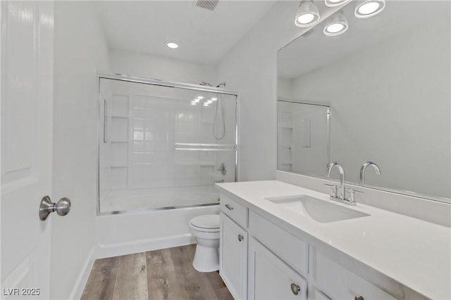 full bathroom featuring toilet, vanity, shower / bath combination with glass door, and hardwood / wood-style floors