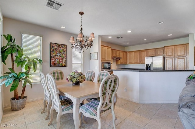 tiled dining room with plenty of natural light and a chandelier