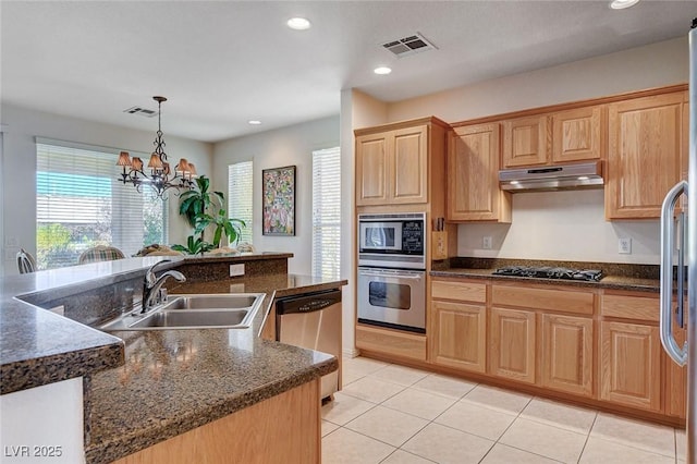 kitchen with appliances with stainless steel finishes, pendant lighting, sink, a chandelier, and light tile patterned floors