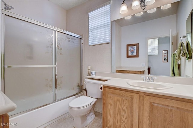 full bathroom featuring tile patterned floors, toilet, vanity, a wealth of natural light, and enclosed tub / shower combo