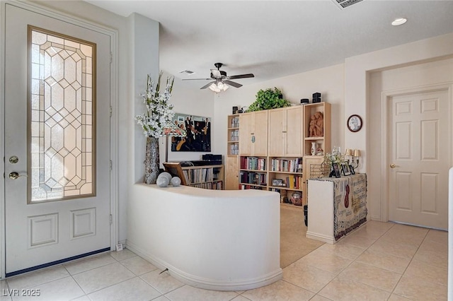 foyer featuring ceiling fan, a healthy amount of sunlight, and light tile patterned floors