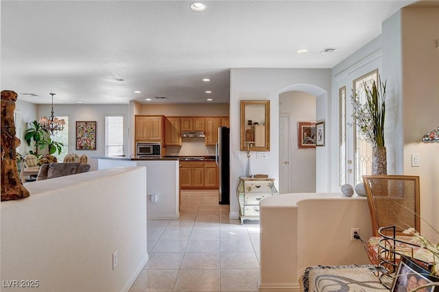 kitchen featuring light tile patterned flooring, appliances with stainless steel finishes, decorative light fixtures, and a notable chandelier