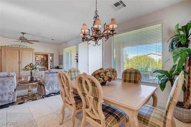 dining space with ceiling fan with notable chandelier and light tile patterned flooring