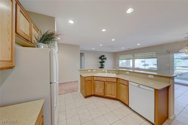 kitchen featuring white appliances, light countertops, a sink, and recessed lighting