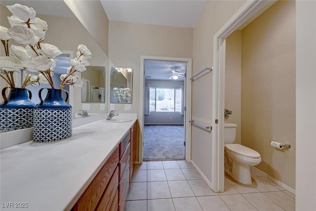 bathroom featuring toilet, tile patterned flooring, vanity, and baseboards