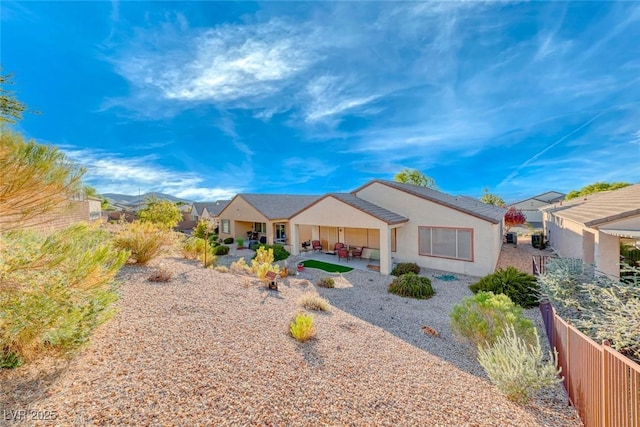 ranch-style house with a patio, fence, a residential view, and stucco siding