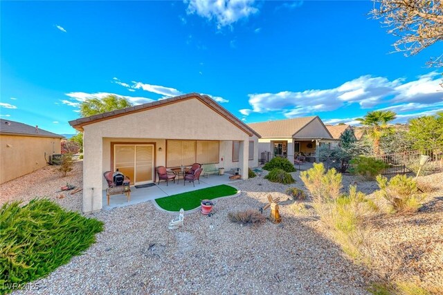 back of house featuring a patio, fence, and stucco siding