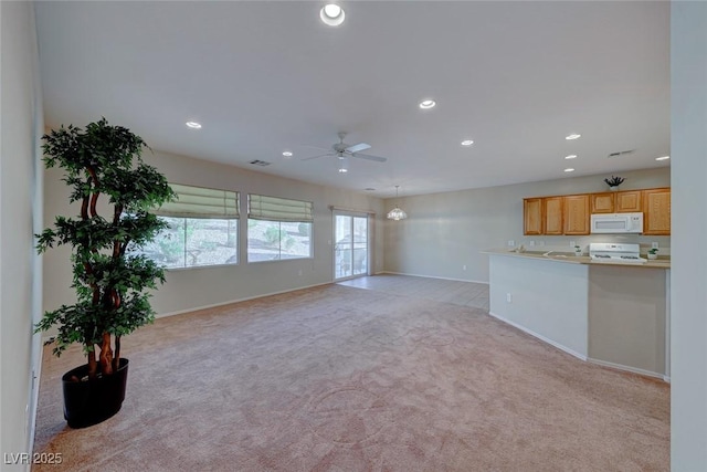 unfurnished living room featuring recessed lighting, light carpet, ceiling fan, and baseboards