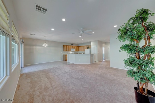 unfurnished living room featuring light colored carpet, visible vents, baseboards, and recessed lighting