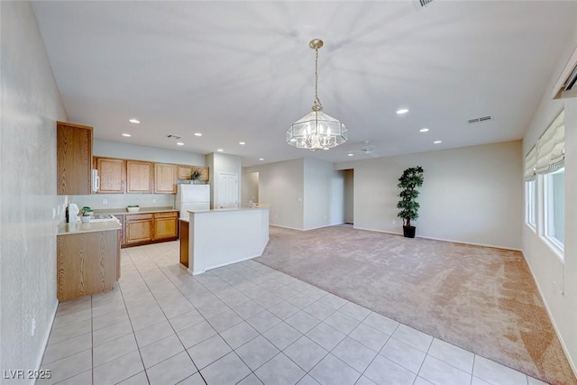 kitchen with light carpet, white appliances, visible vents, light countertops, and a notable chandelier