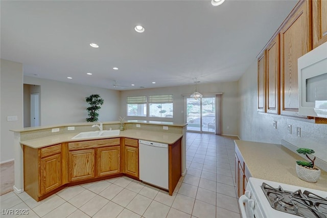 kitchen with white appliances, light tile patterned floors, light countertops, a sink, and recessed lighting