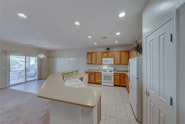 kitchen with light countertops, visible vents, a kitchen island with sink, a sink, and white appliances