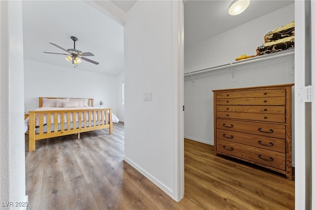 bedroom with hardwood / wood-style flooring, ceiling fan, and lofted ceiling