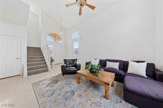 living room featuring high vaulted ceiling, ceiling fan, and light tile patterned flooring