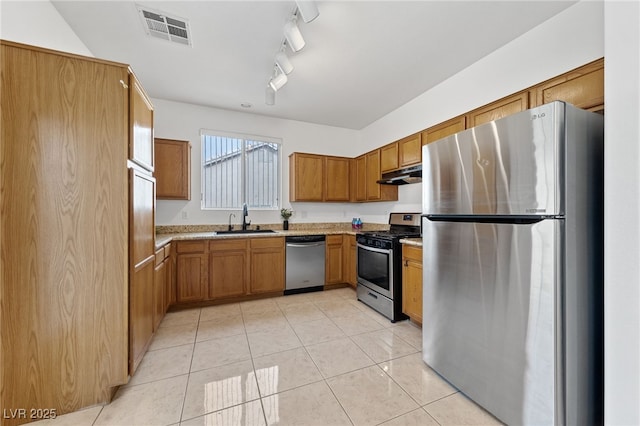 kitchen with stainless steel appliances, sink, light tile patterned floors, and track lighting