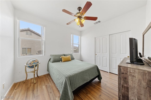 bedroom with hardwood / wood-style flooring, ceiling fan, and a closet