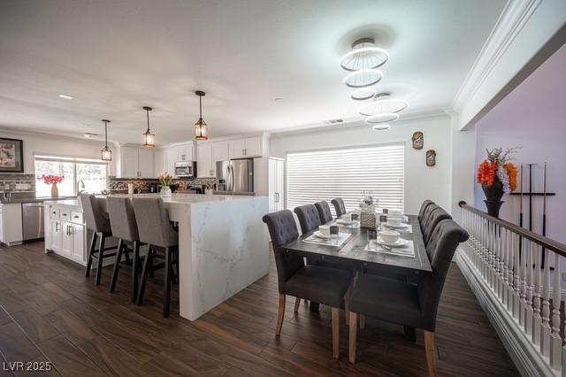 dining space featuring dark wood-type flooring and ornamental molding