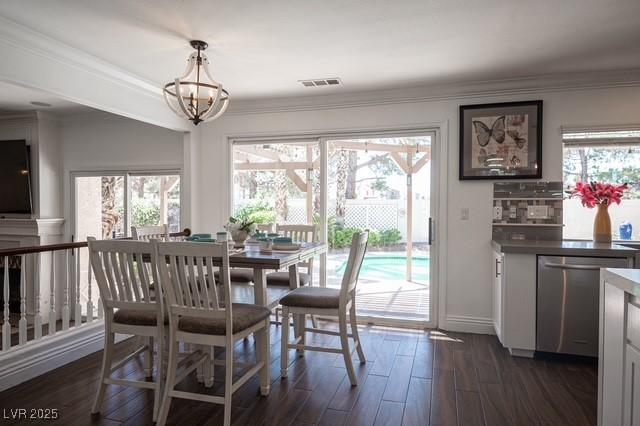 dining space with crown molding, dark hardwood / wood-style floors, and a wealth of natural light