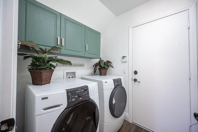 clothes washing area with dark hardwood / wood-style floors, washing machine and dryer, and cabinets