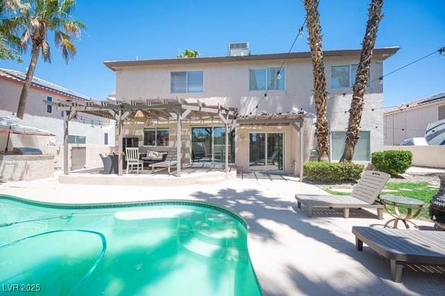 back of property with a pergola, a patio area, central air condition unit, and exterior kitchen