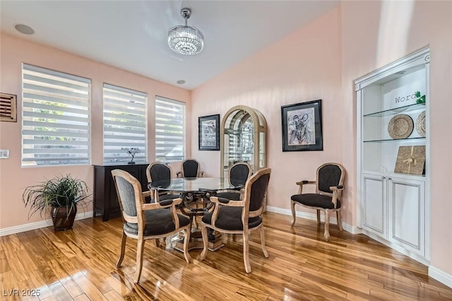 dining area featuring vaulted ceiling and light hardwood / wood-style floors