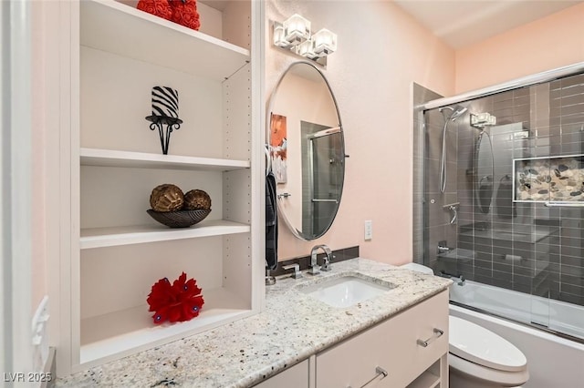 full bathroom with vanity, combined bath / shower with glass door, and toilet