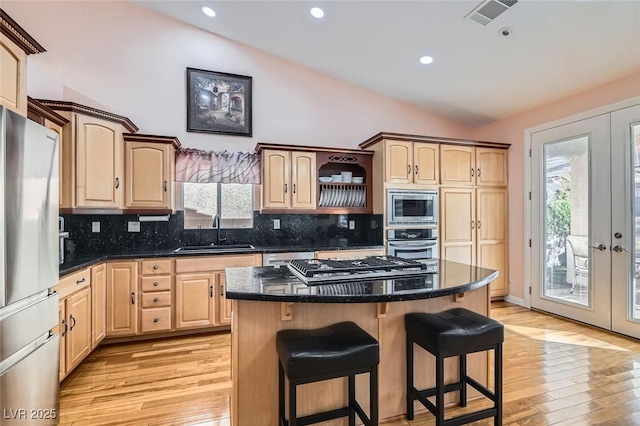 kitchen featuring french doors, appliances with stainless steel finishes, sink, and a kitchen island