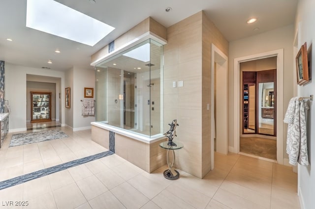 hallway with light tile patterned flooring and a skylight