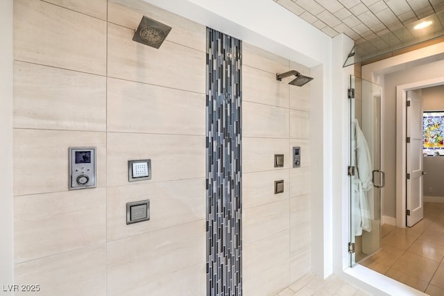 bathroom with tile patterned flooring and tiled shower