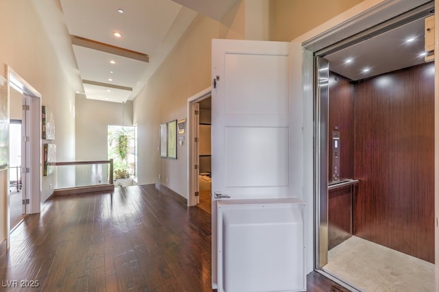 hall with dark hardwood / wood-style floors and elevator