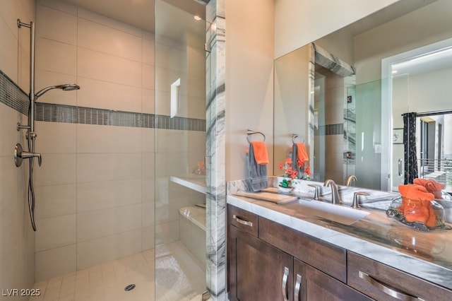 bathroom featuring a tile shower and vanity