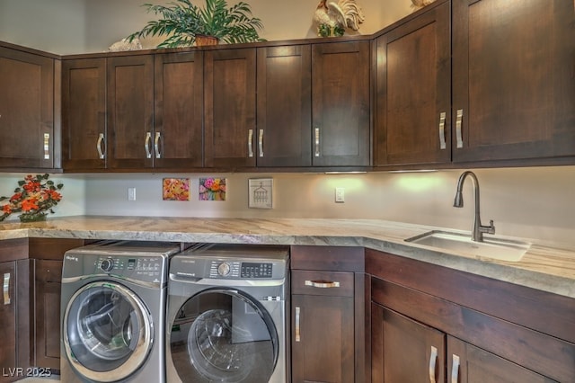 washroom with sink, cabinets, and washing machine and clothes dryer