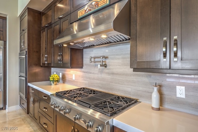 kitchen with tasteful backsplash, island exhaust hood, appliances with stainless steel finishes, and dark brown cabinets