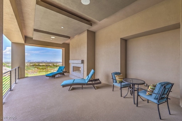 view of patio featuring an outdoor fireplace and a balcony