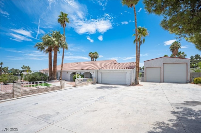 mediterranean / spanish-style home featuring a tile roof, fence, and stucco siding