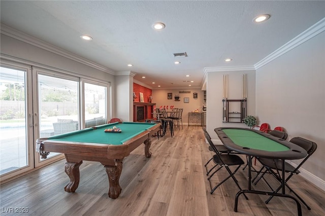 recreation room featuring light wood finished floors, baseboards, crown molding, a bar, and recessed lighting