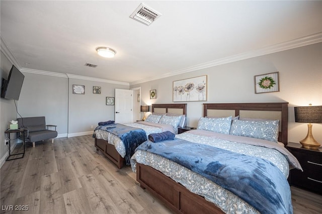 bedroom featuring light wood-style flooring, visible vents, and ornamental molding