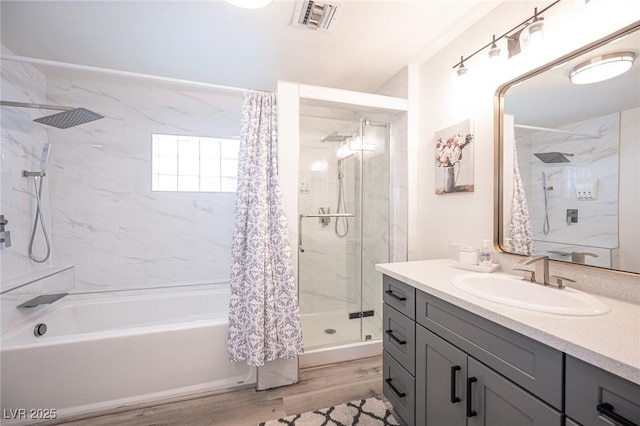 bathroom featuring visible vents, shower / tub combo with curtain, vanity, and wood finished floors