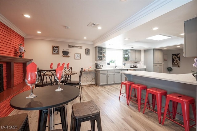 dining room featuring light wood-style floors, recessed lighting, visible vents, and crown molding