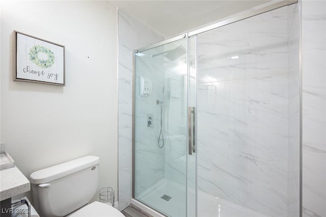 full bathroom with a marble finish shower, vanity, and toilet