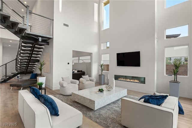 living room with light hardwood / wood-style flooring and a high ceiling