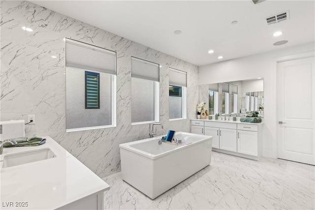 bathroom featuring vanity and a bath