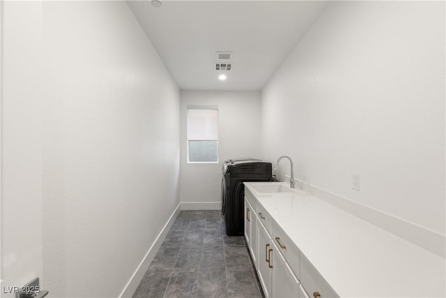 clothes washing area with sink and cabinets