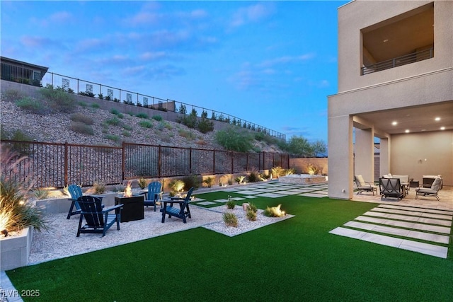 yard at dusk featuring an outdoor fire pit and a patio area