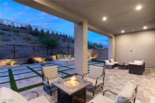 patio terrace at dusk with an outdoor living space with a fire pit