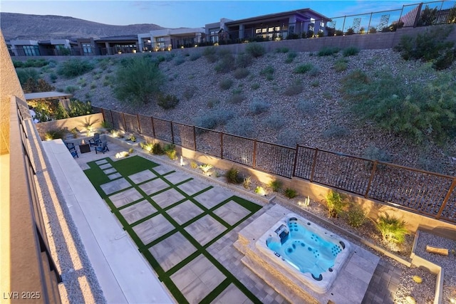 exterior space with an outdoor hot tub, a mountain view, and a patio