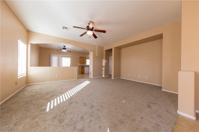 unfurnished living room featuring light colored carpet and ceiling fan