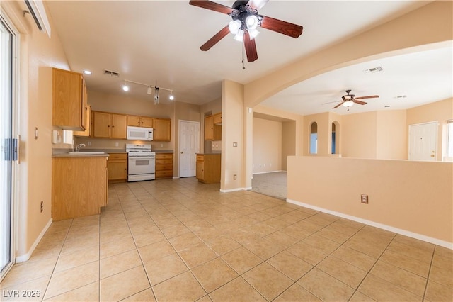 kitchen with light tile patterned flooring, rail lighting, sink, ceiling fan, and white appliances